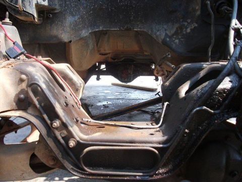 1990 Ford Bronco - Undercarriage view shows the frame, suspension, and drivetrain of a vehicle, possibly undergoing modifications.
