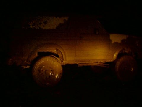 1995 Ford Bronco - This vehicle appears to be stuck in mud, with its tires caked in dirt.