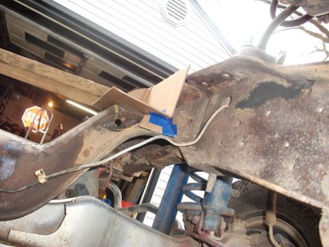 1990 Ford Bronco - This image shows a close-up view of a vehicle's frame and suspension components, with some cardboard and tape in place.
