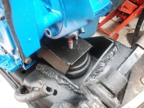 1990 Ford Bronco - Close-up of a custom engine mount with visible welding and a blue engine block.