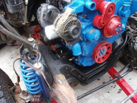 1990 Ford Bronco - Engine with turbocharger and suspension components, likely part of a custom build or swap.