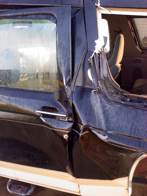 1990 Ford Bronco - Close-up of severe damage to a vehicle's side door and interior structure.