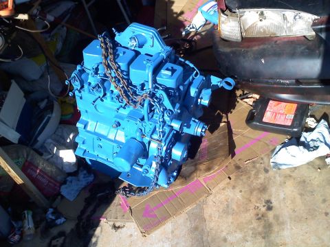 1990 Ford Bronco - A blue engine with chains is shown, possibly for a 4BTA swap, with a car's headlight visible in the background.
