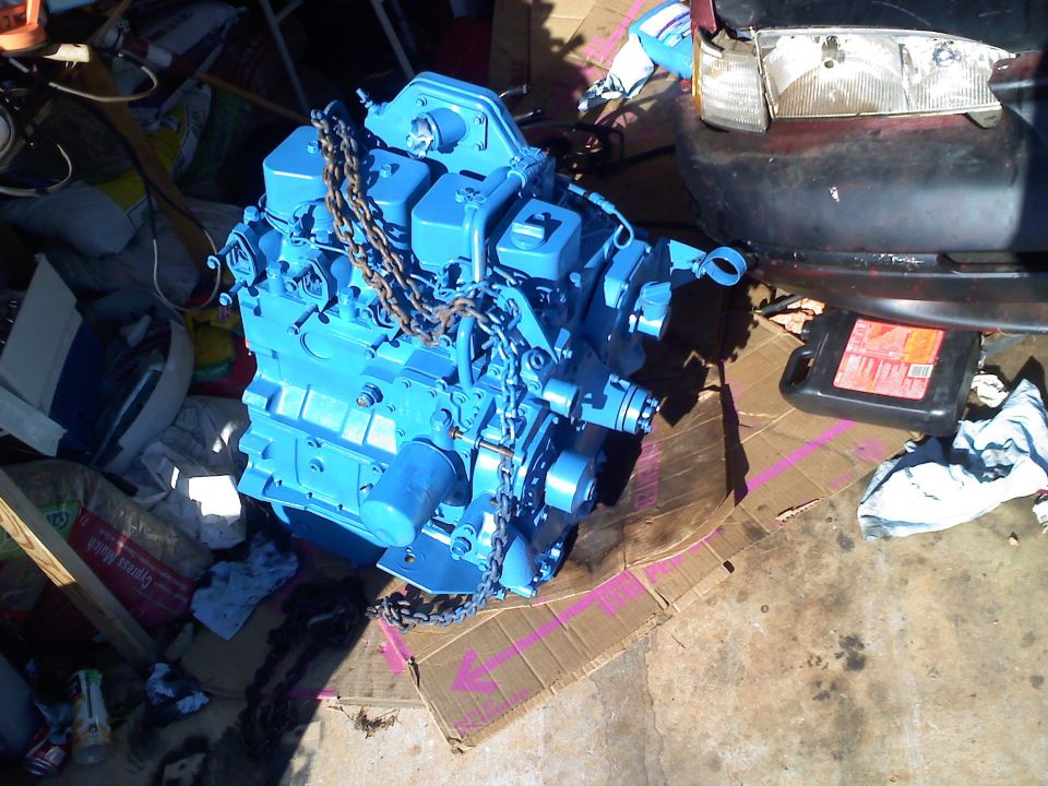 Blue engine with chains, next to a car headlight