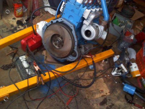 1990 Ford Bronco - Engine assembly with turbocharger and battery, likely undergoing a swap or rebuild.