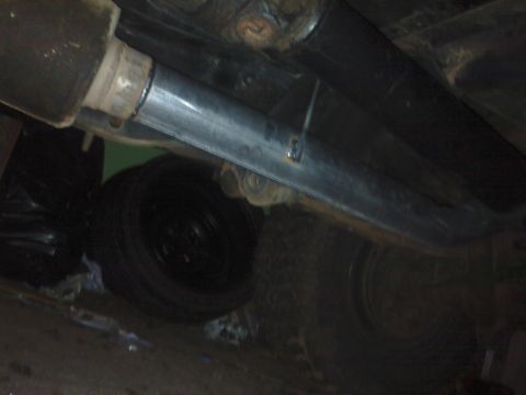 1995 Ford Bronco - Close-up view of a vehicle's undercarriage, showing the exhaust system and a tire.