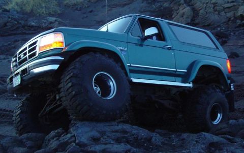 1996 Ford Bronco - This lifted 1996 Ford Bronco navigates a challenging rocky landscape, its off-road capabilities.