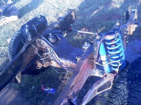 1995 Ford Bronco - Close-up of vehicle frame and suspension parts, possibly undergoing repair or modification.