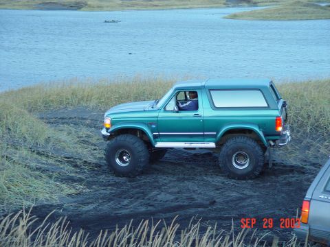 1996 Ford Bronco - A green SUV with large tires is parked on a dirt area next to a body of water. The date stamp reads SEP 29 2003.