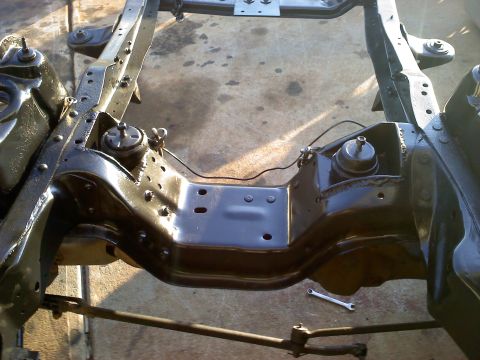 1995 Ford Bronco - Close-up of a vehicle's frame and suspension components, possibly undergoing restoration.
