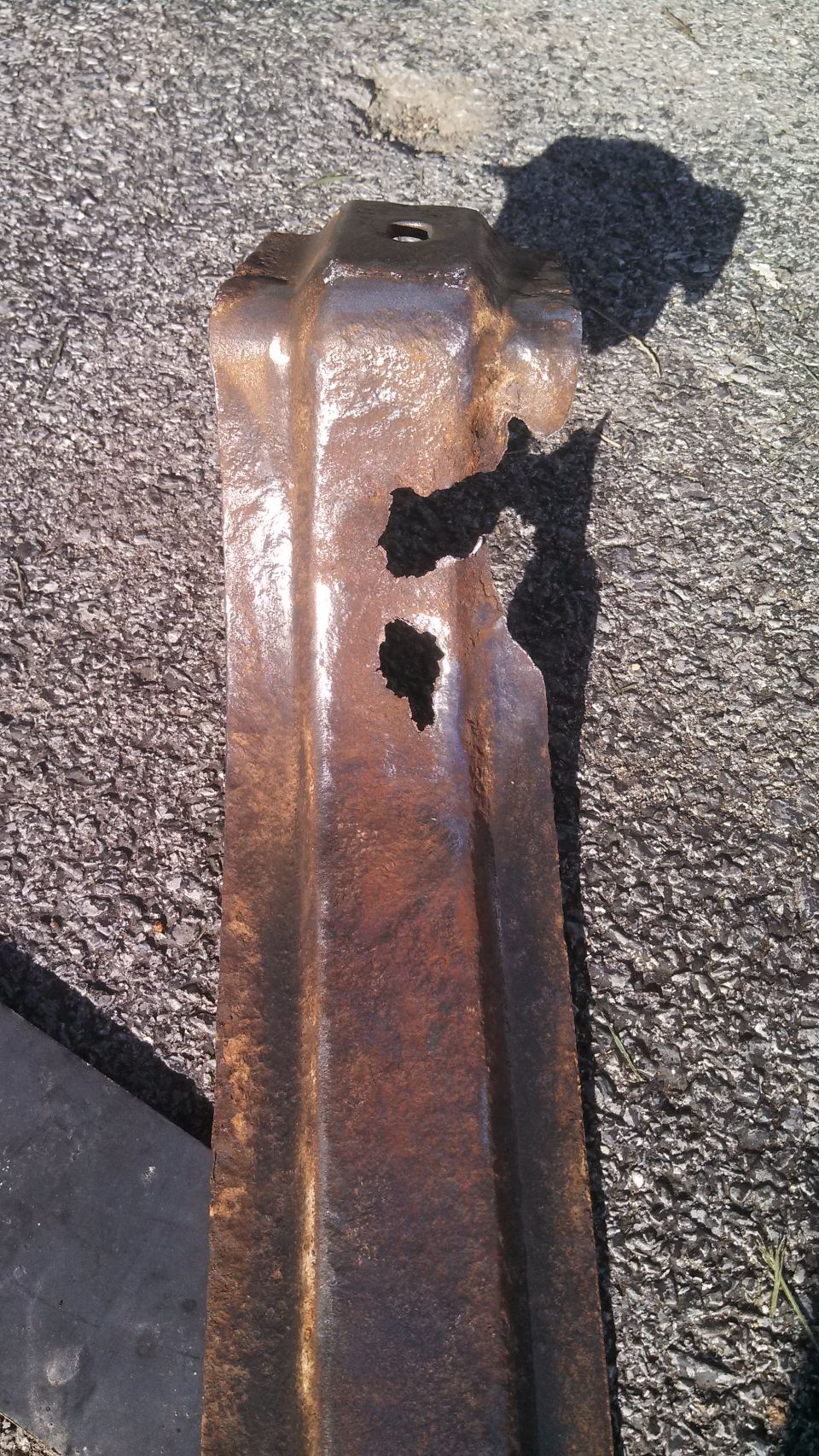 Rusted metal part with holes, Supermotors.net logo visible