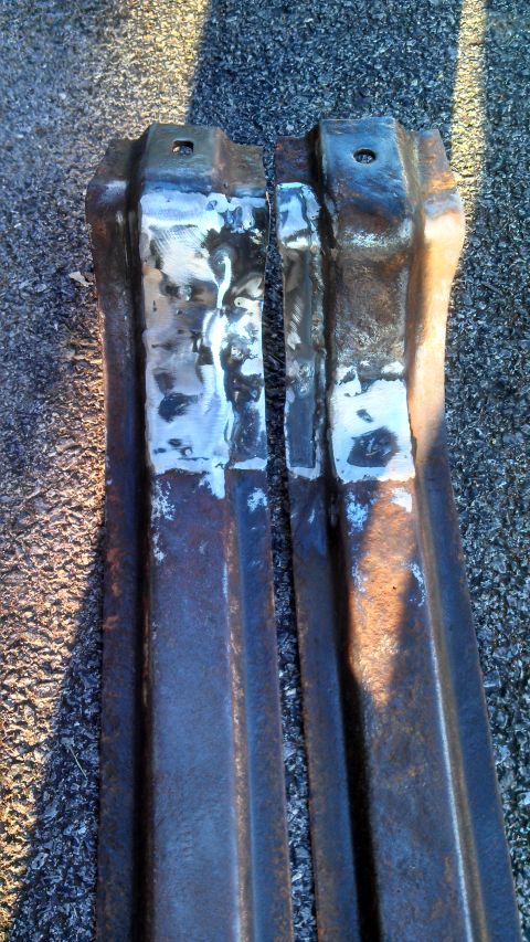 1979 Ford Bronco - These appear to be two heavily rusted and worked-on metal components, possibly from a vehicle's frame.