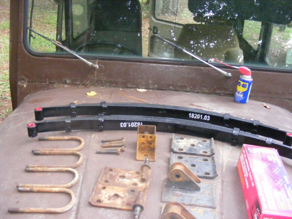 Leaf springs and hardware on a vehicle surface with WD-40 can.
