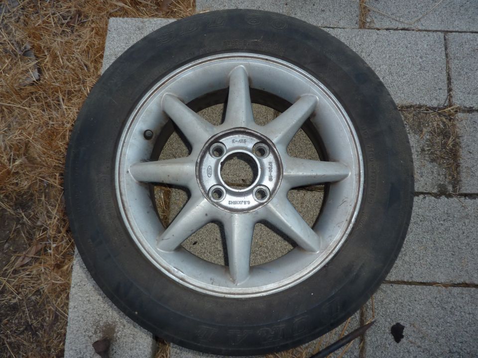 Silver 4-lug alloy wheel with tire