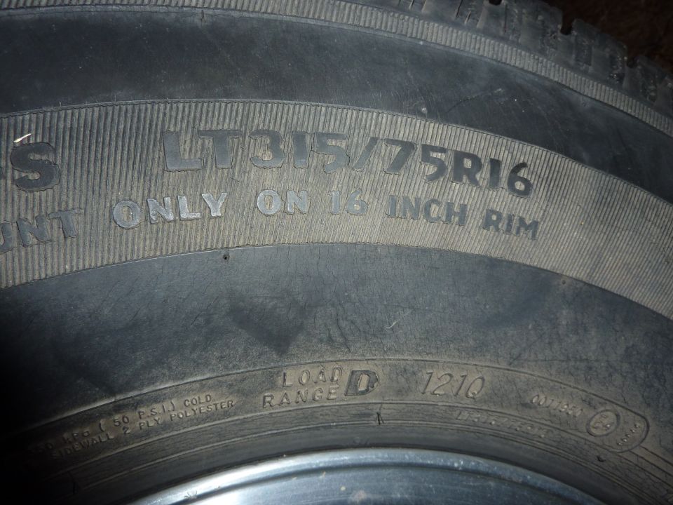 Close-up of a tire showing LT315/75R16 and 16 inch rim information.