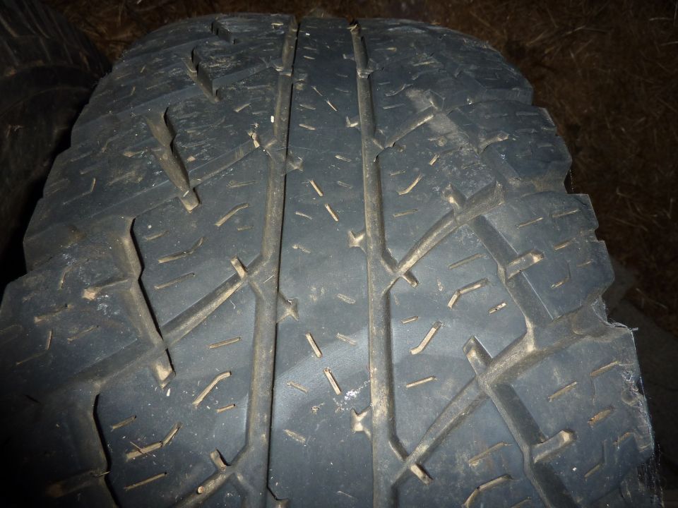 Close-up of a worn tire tread with visible grooves and sipes.