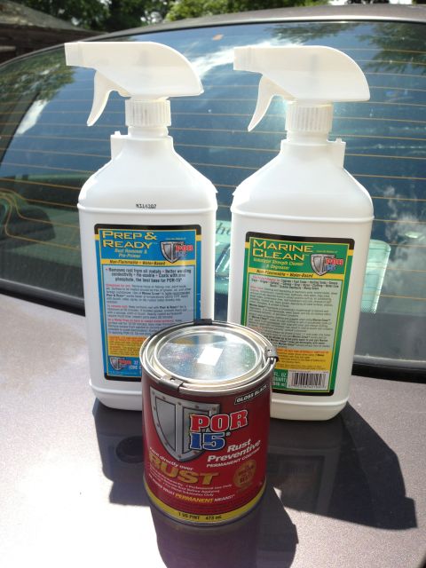2004 Ford Crown Victoria - Two spray bottles of POR-15 Prep & Ready Rust Remover and Marine Clean degreaser sit next to a can of POR-15 Gloss Black Rust Preventive Pe…