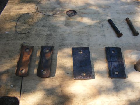 1978 Ford Bronco - Various metal parts and bolts are laid out on a wooden surface.