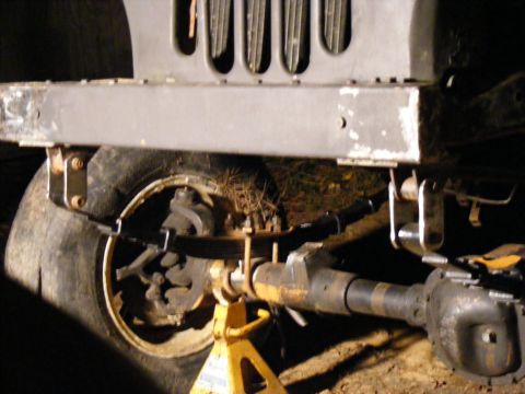 1978 Ford Bronco - Close-up view of a vehicle's front axle and suspension components, with a tire visible.