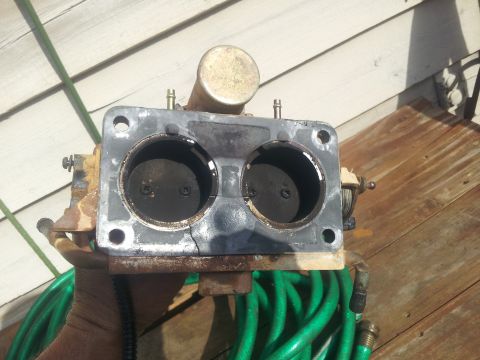 1988 Ford Bronco - A close-up view of a carburetor, showing its internal components and mounting holes.