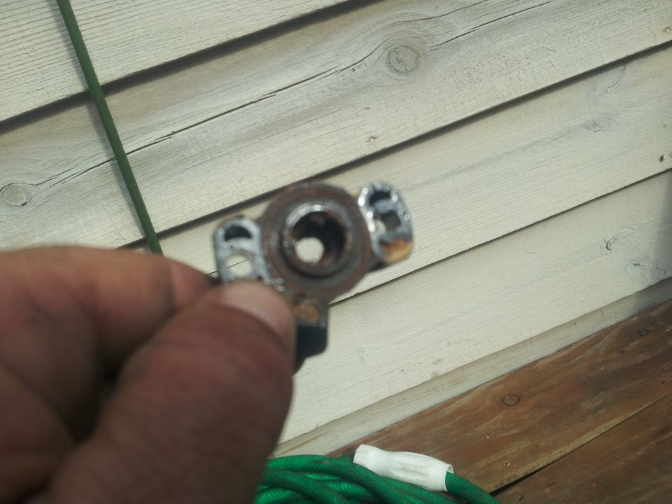 Metal part with circular opening and two mounting points, held in hand