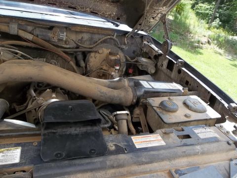 1995 Ford Bronco - Engine bay of a 1995 Ford Bronco, showing various components and hoses.