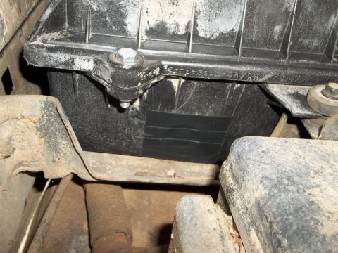 1995 Ford Bronco - A close-up view of a battery tray, showing some black tape applied to the side of the battery housing.