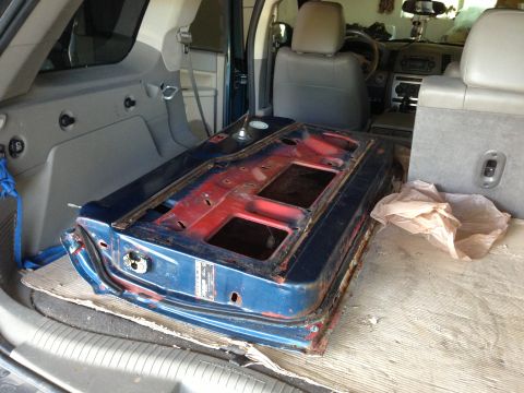 1964 Ford Fairlane - A blue car door with visible red primer and rust is placed in the cargo area of an SUV.