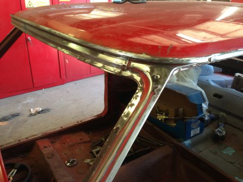 1964 Ford Fairlane - Close-up of a vintage car's roofline and window frame, showing metalwork and red paint.
