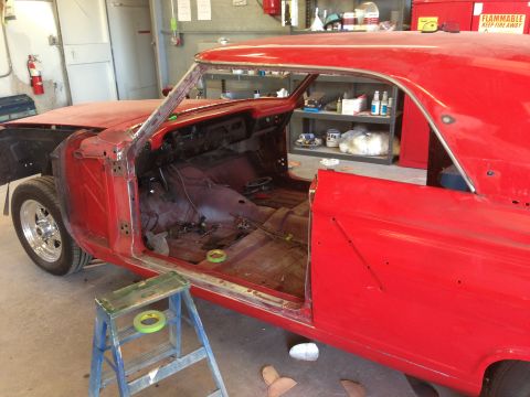 1964 Ford Fairlane - The interior of a red 1964 Ford Fairlane is visible, stripped down for restoration work.