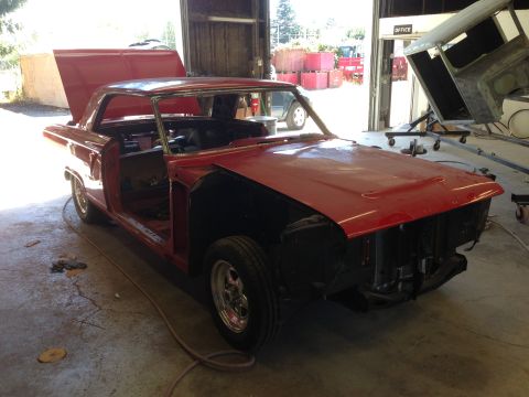 1964 Ford Fairlane - A red 1964 Ford Fairlane is in a garage, appearing to be in the process of restoration with its hood and doors open.