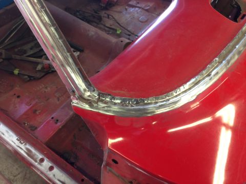 1964 Ford Fairlane - The interior of a car is visible, with red paint and chrome trim, undergoing restoration work.