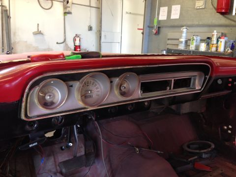 1964 Ford Fairlane - The interior of a classic car shows its dashboard with gauges and wiring, ready for restoration.