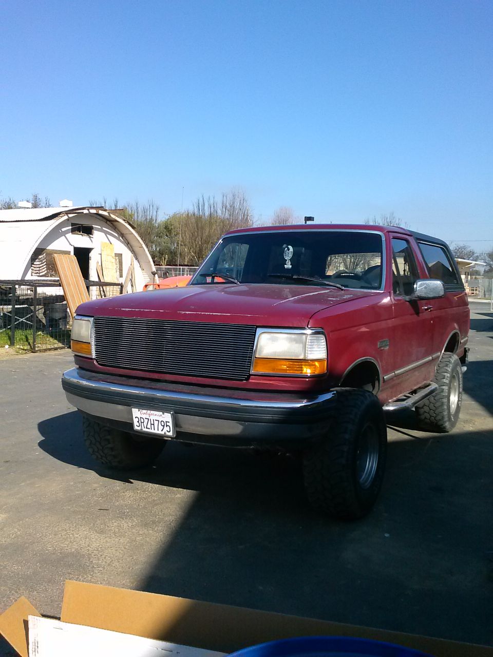 Red 1992 Ford Bronco front 3/4 view with aftermarket grille and tires