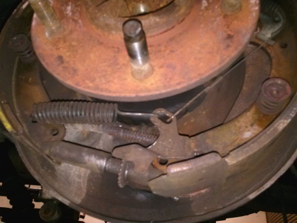 Drum brake assembly with rusted components and a Supermotors.net watermark
