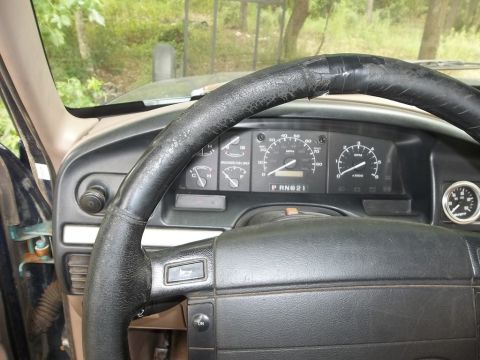 1995 Ford Bronco - The interior of a 1995 Ford Bronco shows a worn steering wheel and the main dashboard gauges.