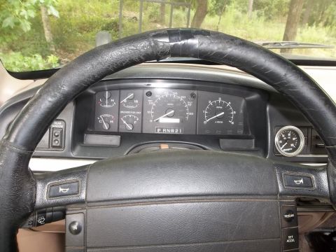 1995 Ford Bronco - Interior view of a 1995 Ford Bronco, dashboard gauges and a worn steering wheel.