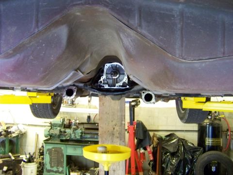 1999 Mercury Grand Marquis - The underside of a vehicle is shown on a lift, with the transmission removed and exhaust pipes visible.