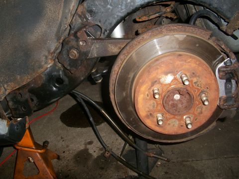 2001 Ford Crown Victoria - The rear brake assembly shows significant rust on the rotor and surrounding components.