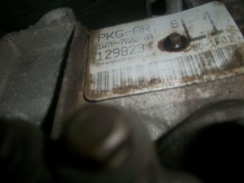 2001 Ford Crown Victoria - A close-up view of a part with a label containing alphanumeric text and a barcode.