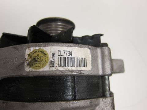 2001 Ford Crown Victoria - This is a close-up of an alternator part, showing its label and a quality assurance seal.