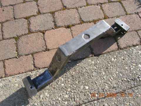 1995 Ford Bronco - A metal trailer hitch receiver part is shown resting on a paved surface with visible date stamp.