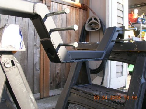 1995 Ford Bronco - A custom-fabricated engine crossmember is shown mounted on sawhorses, with visible bolts and welds.