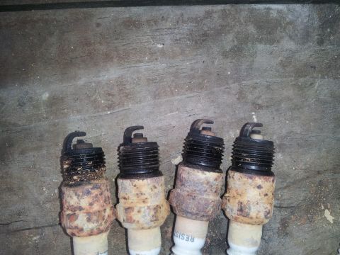 1988 Ford Bronco - A set of four spark plugs, showing significant rust and wear.