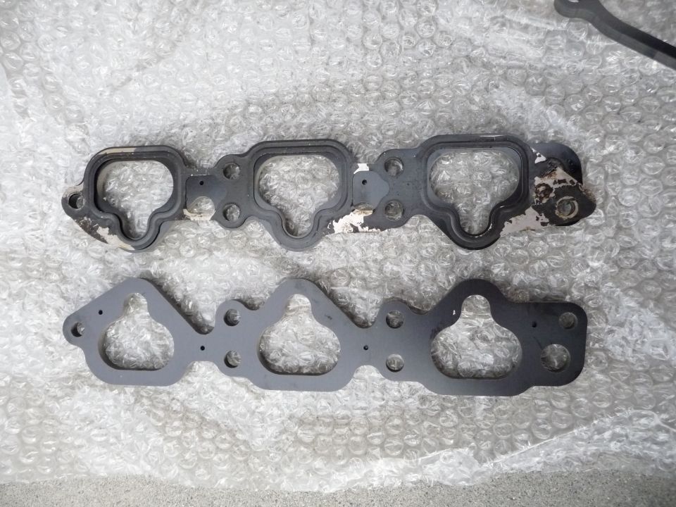 Two intake manifold gaskets, one worn and one new