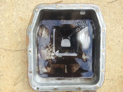 1988 Ford Bronco - Oil pan contains dark fluid and debris, suggesting potential engine issues.