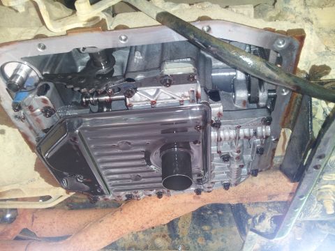 1988 Ford Bronco - The transmission pan has been removed, revealing the filter and internal workings of the transmission.