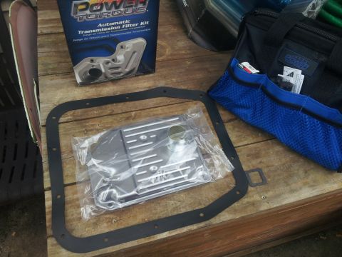 1988 Ford Bronco - A new automatic transmission filter kit and gasket are laid out on a wooden surface, ready for installation.