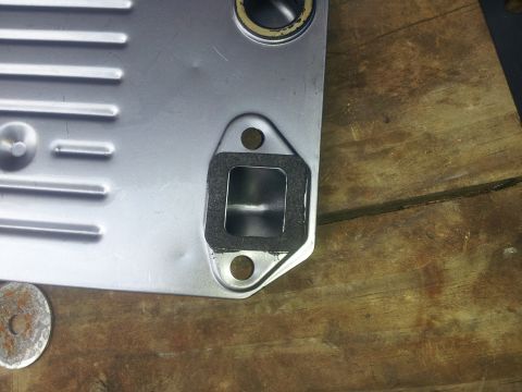 1988 Ford Bronco - Close-up of a vehicle part, likely an oil cooler, with a gasket and mounting holes.