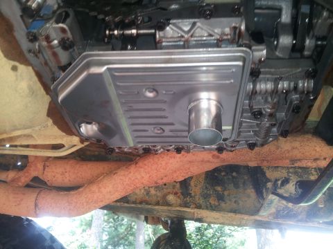 1988 Ford Bronco - Close-up view of the underside of a vehicle, showing the transmission pan and exhaust system.